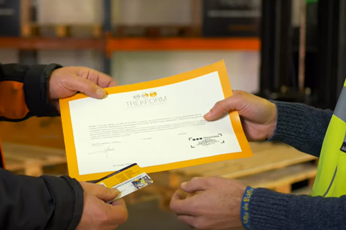 Formador entregando la acreditración del curso de carretillas elevadoras en barcelona una vez superado